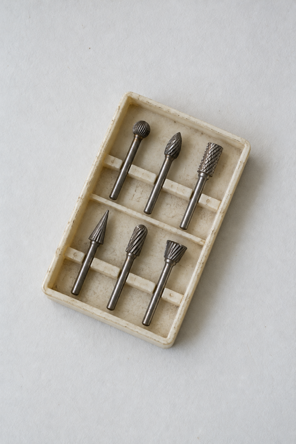 Original Just Brilliant craft study: six steel rotary burs in a worn ivory tool case.