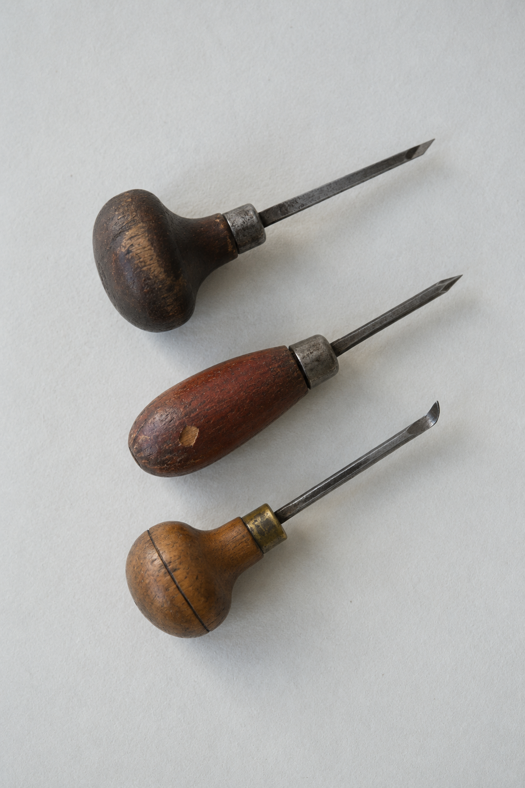 Original Just Brilliant craft study: three used wooden-handled engraving tools on pale paper.