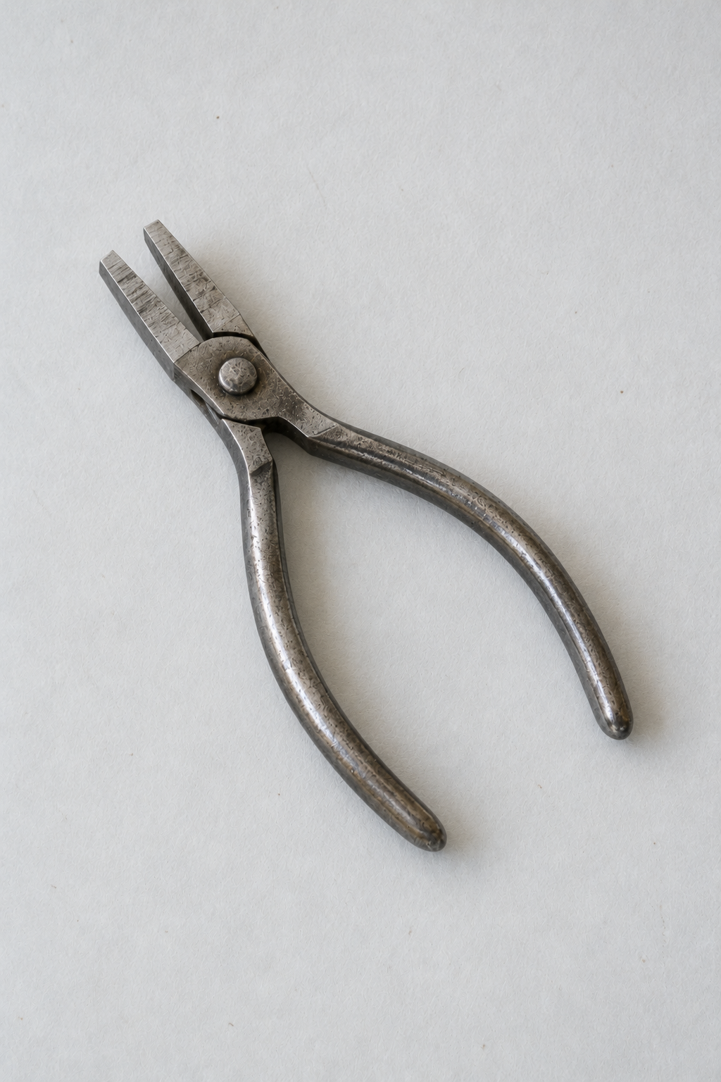 Original Just Brilliant craft study: flat-nose jeweler's pliers with dull steel handles.